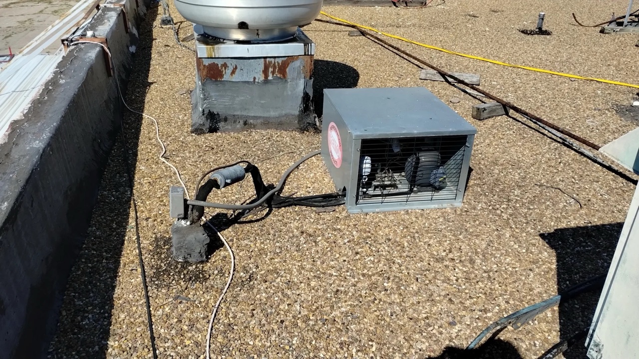 Rooftop HVAC equipment and ventilation units installed on a gravel-surfaced built-up commercial roof