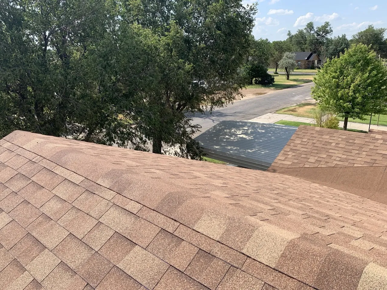 Completed brown dimensional architectural shingle roof replacement showing clean ridge lines and professional installation — 5 Star Roofing