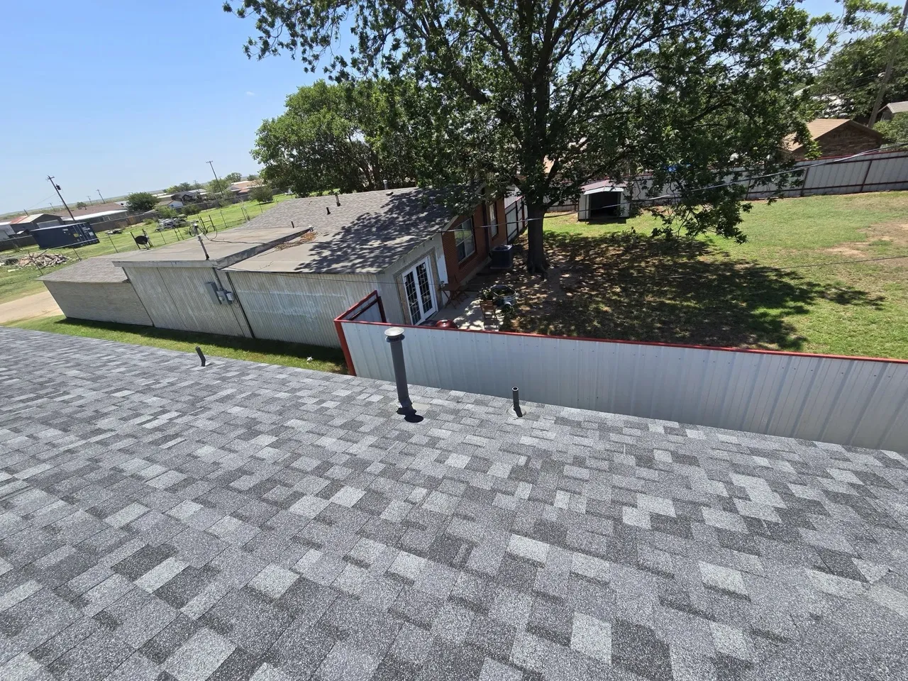 Completed gray dimensional asphalt shingle roof with prominent ridge venting after wind damage repair — 5 Star Roofing