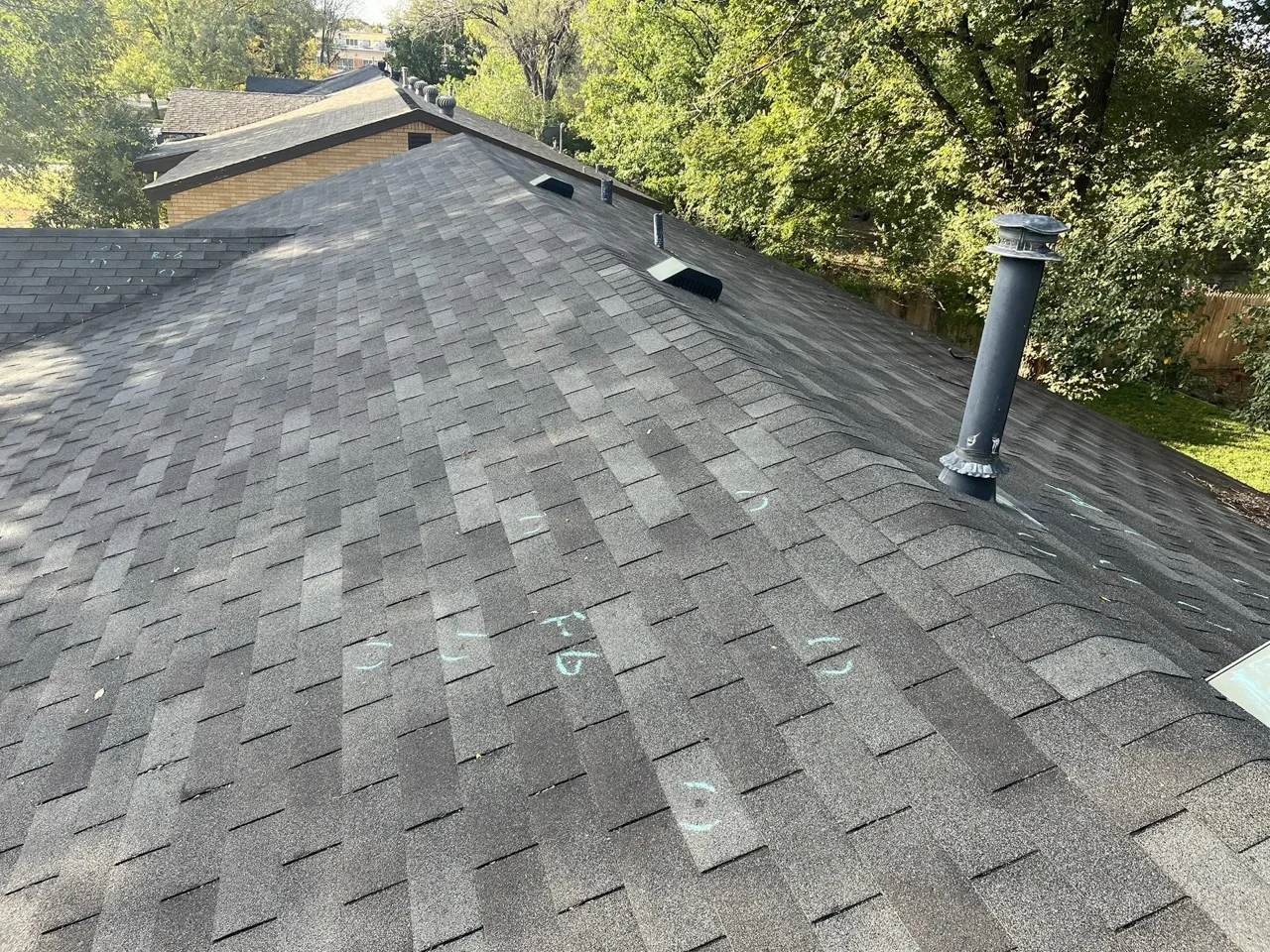Hail impact damage chalk-marked on a residential shingle roof — documentation prepared for insurance adjuster review